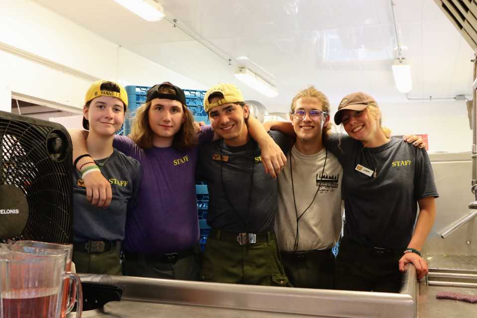 Staff stand shoulder to shoulder and smile at the camera